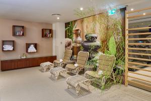 a waiting room with chairs and a large mural at Occidental Faro in Faro