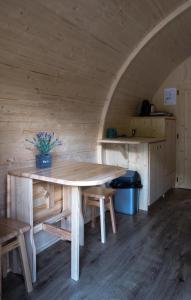 a large wooden table in a room with a kitchen at LeafMaxi - Camping du Nord in Bourscheid
