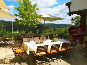 einen Esstisch mit Stühlen und einem Sonnenschirm auf einer Terrasse in der Unterkunft Berghotel Wintersberg in Bad Ems