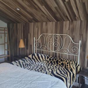 a bed with a metal headboard in a bedroom at Le Jasmin chalet complet Rivière Kayak Nature in Saint-Paulin