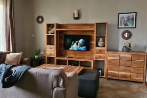 a living room with a television in a wooden entertainment center at Bellissimo Vacation Home in Arusha