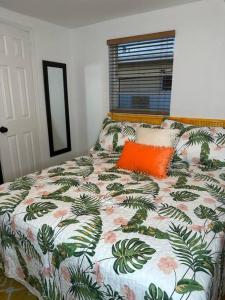 an orange pillow on a bed in a bedroom at Sleeps 3, Casa Tropical in Miami in Miami