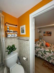 a bathroom with a toilet and a bed in a room at Sleeps 3, Casa Tropical in Miami in Miami
