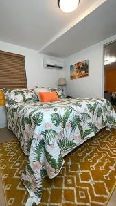 a bedroom with a bed with a floral bedspread on it at Sleeps 3, Casa Tropical in Miami in Miami