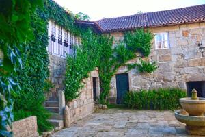 a stone building with a fountain in front of it at Casa De Santa Comba in Cabeceiras de Basto