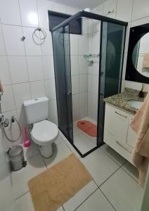 a bathroom with a toilet and a glass shower at Quarto e Sala Monte Paradiso in Maceió +10 photos