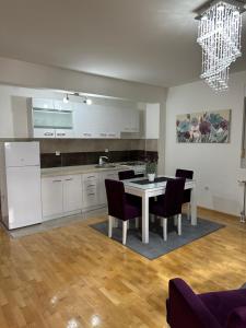 a kitchen and dining room with a table and chairs at Nis Apartment in Niš
