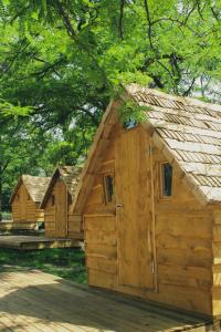 a row of wooden huts with trees in the background at Camping Osuna in Madrid