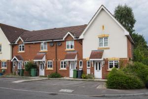 a row of brick houses in a parking lot at Maidstone villa 3bedroom free sports channels park in Maidstone