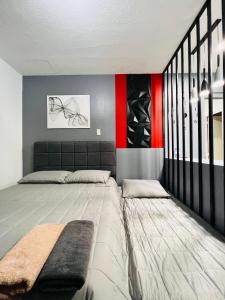 1 dormitorio con 1 cama y pared roja y negra en *Top Choice Awardee B 2023, en Iloilo City