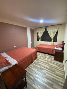 a hotel room with two beds in a room at Elsita departamento vacacional in Baños