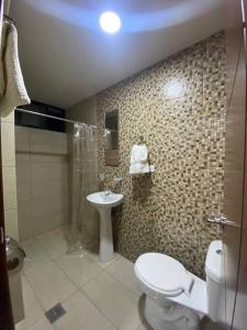 a bathroom with a toilet and a sink at Elsita departamento vacacional in Baños