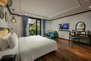 a bedroom with a large white bed and a desk at Media Central Hotel & Spa in Hanoi