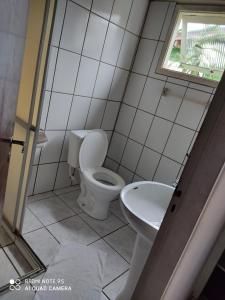 a bathroom with a toilet and a sink at Chales Mata Atlantica De Ubatuba in Ubatuba