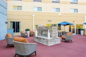 a patio with a fireplace and chairs and a building at Fairfield Inn & Suites by Marriott Columbia in Columbia