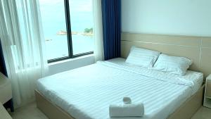 a bed with a box on it in a room with a window at Comfortzone Apartment in Nha Trang