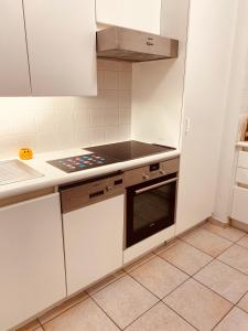 a kitchen with white cabinets and a stove top oven at Room in flat 174 in Ghent