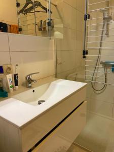 a white bathroom with a sink and a shower at Room in flat 174 in Ghent