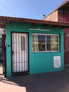un edificio verde con puerta y ventanas en Ruta del vino Alojamientos en Maipú
