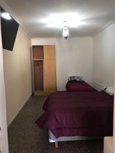 1 dormitorio con 2 camas y lámpara de araña en Ruta del vino Alojamientos en Maipú
