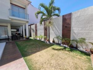 a garden in front of a house with palm trees at Tourist House in Santa Cruz de la Sierra