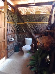 a bathroom with a toilet in a hut at Cabañas Mangle House in Buenaventura