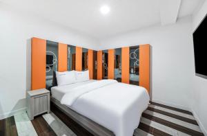 a bedroom with a large white bed with an orange headboard at OU Hotel in Daegu