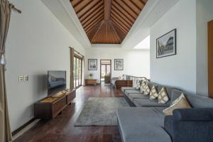a living room with a couch and a tv at Villa Kaira Estate in Canggu
