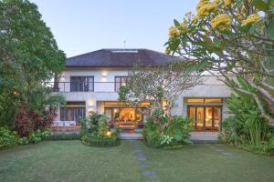 a large house with a garden in front of it at Villa Kaira Estate in Canggu
