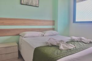 1 Schlafzimmer mit 2 Betten mit weißer Bettwäsche und Kissen in der Unterkunft Cupe Beach Living - Royal 206 in Porto De Galinhas