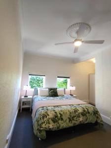 1 dormitorio con 1 cama y ventilador de techo en Windarra on High, en Launceston