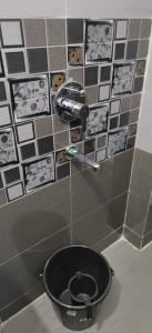 a bathroom with a black toilet in a room at Aashiyana Home Stay, Arera Colony, Bhopal in Bhopal