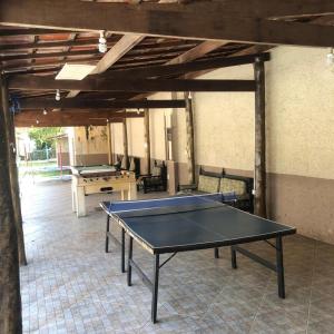 a ping pong table in a room with a table at Chales Mata Atlantica De Ubatuba in Ubatuba