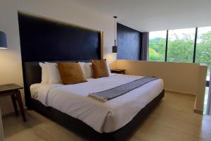 a bedroom with a large bed with a black headboard at Beautiful 2 Story loft near the beach in Playa del Carmen +32 photos
