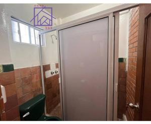 ein Bad mit einer Tür zu einem WC und einem Fenster in der Unterkunft Casa 205 in Tlaxcala de Xicohténcatl