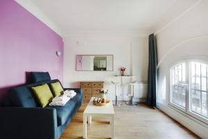 uma sala de estar com um sofá azul e uma mesa em Cozy studio next to Gare de l'Est em Paris