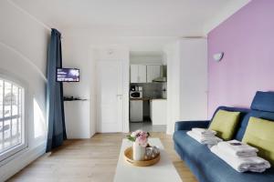 a living room with a blue couch and a table at Cozy studio next to Gare de l'Est in Paris