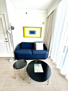 een woonkamer met een blauwe bank en een tafel bij Fontainebleau Miami Beach,Tresor in Miami Beach