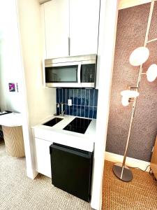 a kitchen with a microwave and a stove top oven at Fontainebleau Miami Beach,Tresor in Miami Beach