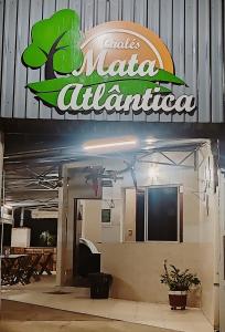 a sign for a restaurant with a tree on it at Chales Mata Atlantica De Ubatuba in Ubatuba