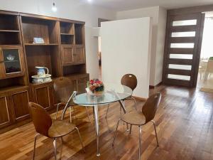 una sala da pranzo con tavolo in vetro e sedie di Sisters- Apartamento cómodo y familiar a Cochabamba