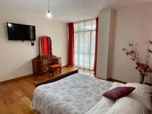una camera con letto e TV a parete di Sisters- Apartamento cómodo y familiar a Cochabamba