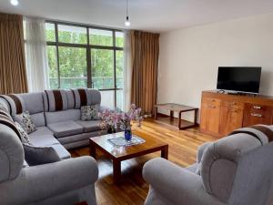 un soggiorno con 2 divani e una TV di Sisters- Apartamento cómodo y familiar a Cochabamba