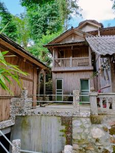 a large wooden house with a balcony in front of it at Mama Gia Homestay in Sa Pa