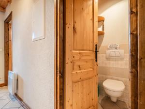 a bathroom with a toilet and a wooden door at Appartement Les Gets, 3 pièces, 6 personnes - FR-1-671-68 in Les Gets