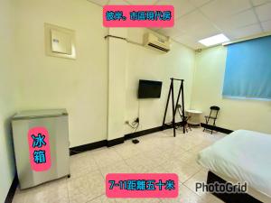 a room with a bed and a tv in it at 模範人家-包棟-彼岸市區館 in Jincheng