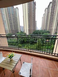 uma varanda com mesa e cadeiras e alguns edifícios em Seaman Light Luxury Apartment em Zhongshan