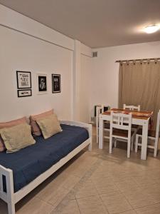 een slaapkamer met een bed en een tafel en een eetkamer bij La Estadía in Puerto Madryn