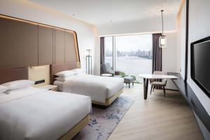 a hotel room with two beds and a flat screen tv at Renaissance Zhuhai Hotel in Zhuhai