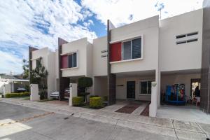 une maison blanche avec des touches de rouge dans une rue dans l'établissement Un espacio privado y cómodo. Casa Nahil., à Jalisco
